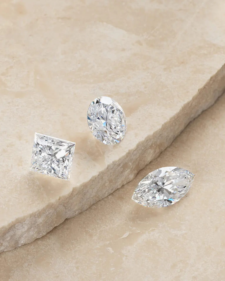 a collection of loose diamonds spread on a stone slab