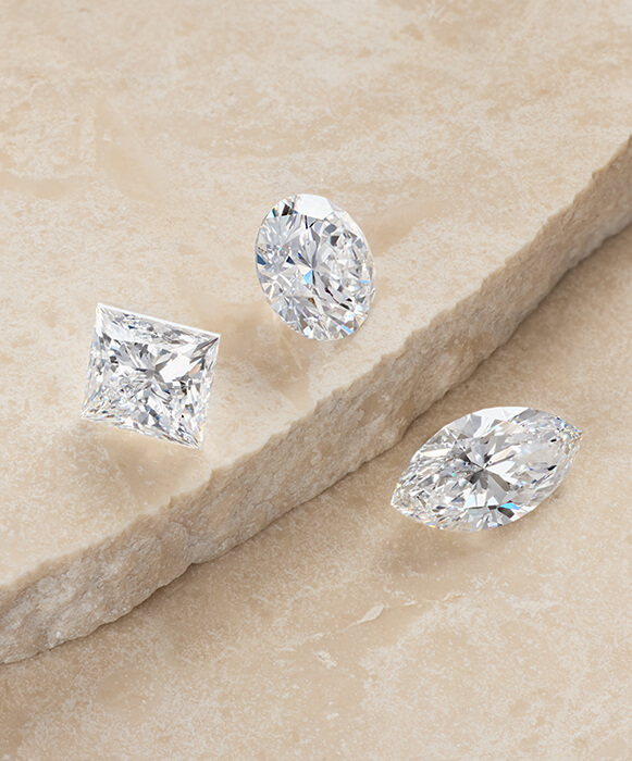 certified GIA loose diamonds in multiple cuts on stone background